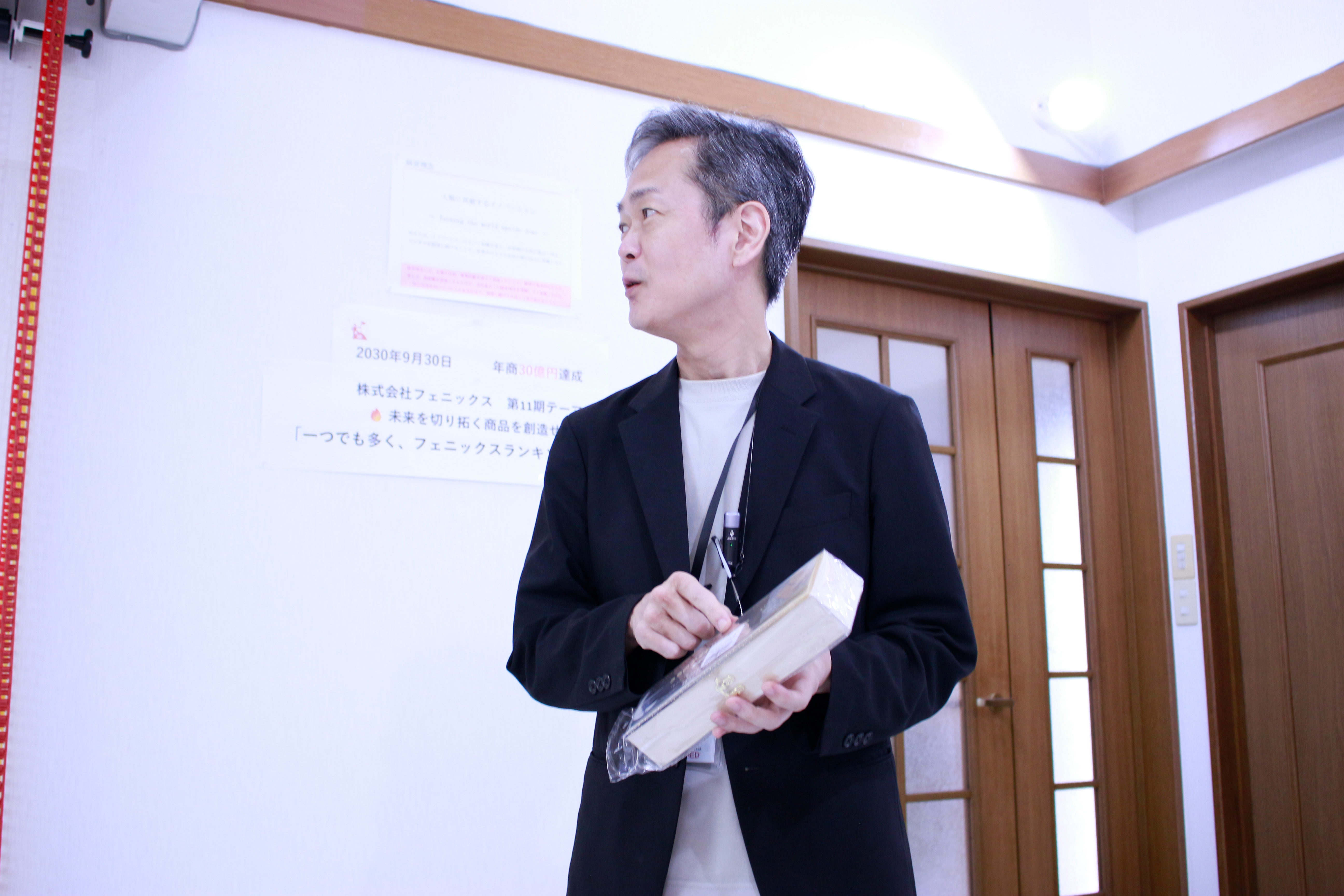 代表が商品を手に説明する様子